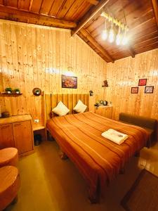 1 dormitorio con 1 cama grande y paredes de madera en Aqua De Vida, en Bhowāli