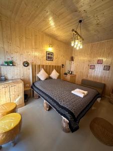a bedroom with a bed in a room with wooden walls at Aqua De Vida in Bhowāli