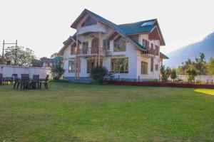 een groot huis met een gazon ervoor bij Burj Cottage , Pahalgam in Pahalgām