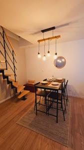 a dining room with a table and chairs and a staircase at Appartement sur cour / 10 min du stade et de la gare in Lens