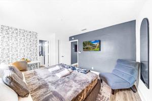 a bedroom with a bed and a blue chair at Water Front Condo - First Floor - Palm Wave Says in Coconut Creek