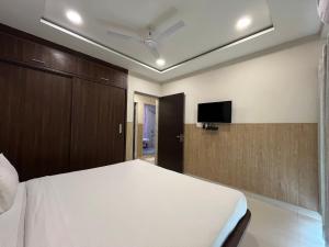 a bedroom with a bed and a flat screen tv at Hotel Shri Radha Nikunj - Opposite Prem Mandir in Vrindāvan