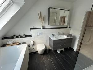 a bathroom with a sink and a toilet and a mirror at Ferienwohnung Dierkings Hof Niedernstöcken in Neustadt am Rübenberge