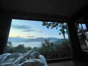 a bed in a room with a large window at Camp Mai Mee Chue in Pong Yaeng +168 photos