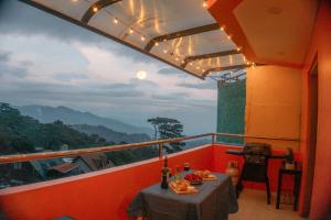 Cozy Baguio House - Outlook Drive (DOT accredited) في باغيو: شرفة مع طاولة وإطلالة على الجبال