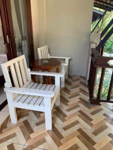 une chambre avec deux chaises blanches et une table dans l'établissement Wind Beach Resort, à Koh Tao