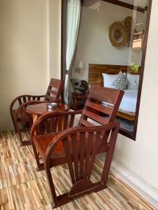 um quarto com uma mesa e cadeiras e uma cama em Wind Beach Resort em Ko Tao