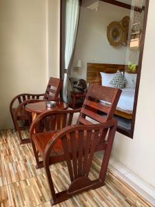 a room with a table and chairs and a bed at Wind Beach Resort in Koh Tao