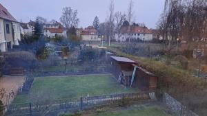 uitzicht op een tuin met huizen op de achtergrond bij Ferienhaus An der Brunnenaue in Stralsund