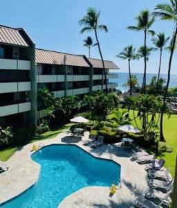 un resort con piscina, sedie e oceano di White Sands Village, Upgraded 2BR, Great View a Kailua-Kona