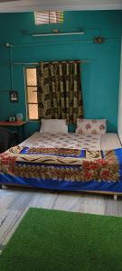 a bed in a room with a blue wall at Welcome paying guest house in Varanasi