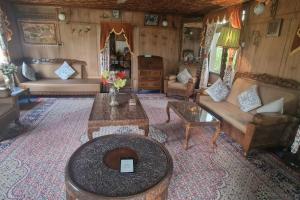 a living room with a couch and a table at Queens Lakehouse in Srinagar