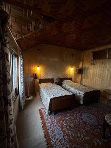 a bedroom with two beds in a room at Queens Lakehouse in Srinagar