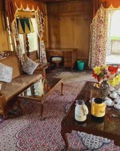 a living room with a couch and a table at Queens Lakehouse in Srinagar