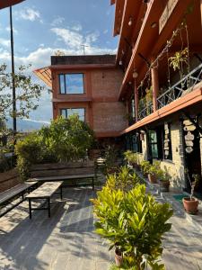 a building with benches and plants in front of it at Nar-Bis Hotel in Pokhara