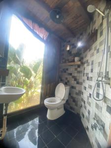 a bathroom with a toilet and a sink and a window at Cat Canh Farm in Ho Chi Minh City