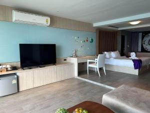 a living room with a bed and a television in a room at Cliff Lanta Suite-Koh Lanta Krabi in Ko Lanta