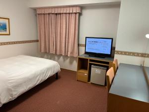 御殿場市にあるホテルアルファーワン御殿場インターのベッドと薄型テレビがあるホテルの部屋