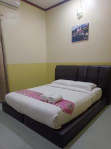 a bed in a room with a black bed frame at Alia Express Seri Ibai Permai in Kuala Terengganu