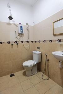 a bathroom with a shower and a toilet and a sink at Alia Express Seri Ibai Permai in Kuala Terengganu