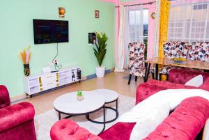 a living room with a red couch and a table at Ruby Modern Homes Nyeri-Skuta in Nyeri