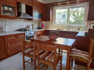 a kitchen with wooden cabinets and a table and chairs at Georgia's Family Apartment in Heraklio Town