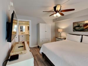 Un dormitorio con una cama y un ventilador de techo. en Regency Towers #206 East - Mermaid Bungalow, en Pensacola Beach 42 fotos más