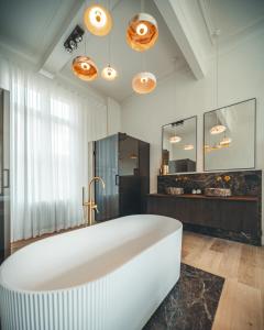 a large white bath tub in a bathroom at B&B Barabas in Bruges +146 photos