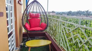 a swing chair sitting on a balcony with a table at Ruby Modern Homes Nyeri-Skuta in Nyeri