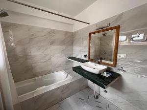 W łazience znajduje się umywalka, wanna i lustro. w obiekcie Hotel New Glacier View w mieście Leh