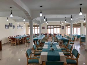 un comedor con mesas y sillas azules en Hotel New Glacier View, en Leh