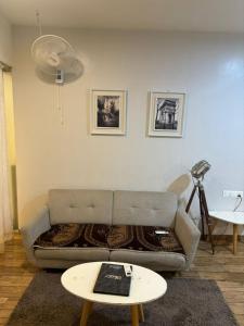 ein Wohnzimmer mit einem Sofa und einem Tisch in der Unterkunft Rajhans Belizia JSM in Surat