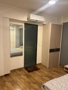 1 Schlafzimmer mit einer Tür, die zu einem Zimmer mit 2 Betten führt in der Unterkunft Rajhans Belizia JSM in Surat