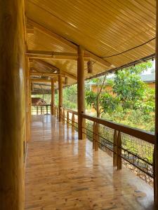 a wooden porch with a wooden floor and a fence at Dìn Homestay Nặm Đăm in Ha Giang