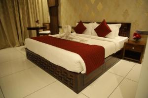 a bedroom with a bed with a stuffed animal on it at Rajathadri Royal Inn in Bangalore