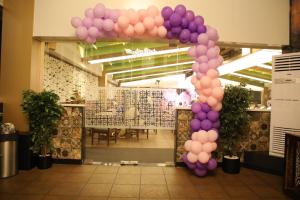 a arch of purple and purple balloons in a room at Rajathadri Royal Inn in Bangalore