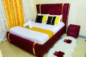 a bedroom with a bed with a red and yellow comforter at Ruby Modern Homes Nyeri-Skuta in Nyeri