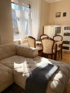 uma sala de estar com um sofá, uma mesa e cadeiras em New Ferry Klaipeda em Klaipėda