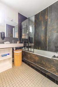La salle de bains est pourvue d'une baignoire et d'un lavabo. dans l'établissement La rose des vents -Magnifique F2 avec Parking 32 Jean Jaures, à Chamalières