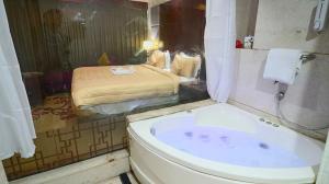 a bathroom with a bath tub and a bed at SkyCity Hotel Gurgaon in Gurgaon