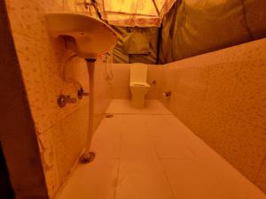 a small bathroom with a sink and a toilet at Tree Bones Camp in Bīr