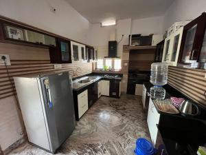 a kitchen with a stainless steel refrigerator in it at Souparnika Homestay in Kannur