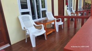 a row of white chairs and a table on a porch at Sleep In Lanta Resort in Ko Lanta