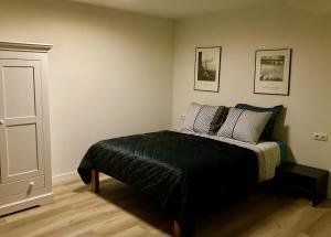 een slaapkamer met een bed en twee foto's aan de muur bij Hoeve de Hoge Swaen in Maastricht