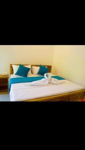 - un lit avec des draps bleus et blancs et des oreillers bleus dans l'établissement ROCK VIEW RELAX Inn, à Sigirîya