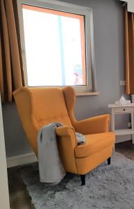 an orange chair sitting in a room with a window at Ferienwohnung im Zentrum mit Balkon und Parkplatz in Gmunden