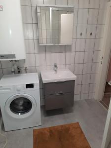 a bathroom with a washing machine and a sink at Ferienwohnung im Zentrum mit Balkon und Parkplatz in Gmunden