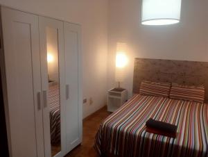 ラスパルマス・デ・グランカナリアにあるCasa Colonial Veguetaのベッドルーム1室(ストライプ毛布付きのベッド1台付)