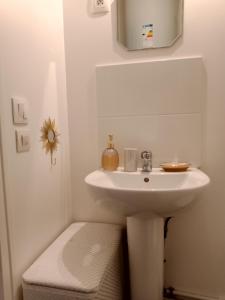 a white bathroom with a sink and a toilet at Joli in Clichy