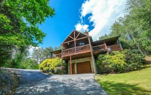 a house with a wrap around porch and a driveway at Dogwood Acres in Pigeon Forge